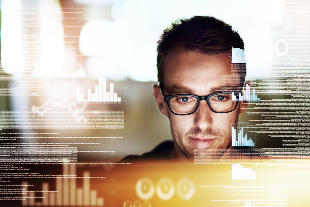 Employee looking at a screen with graph transparent illustrations covering the photo.